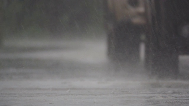 高清慢镜头:雨滴落在街道上。视频素材