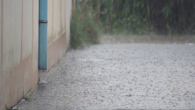 高清慢镜头:雨滴落在街道上。视频素材