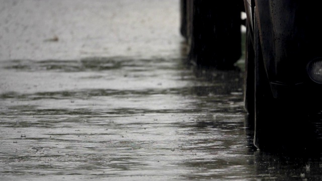 高清慢镜头:雨滴落在街道上。视频素材