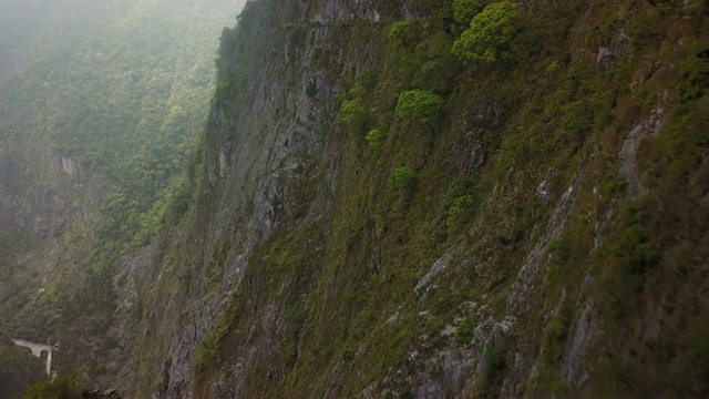 在狭窄的峡谷中，沿着陡峭的悬崖高空飞行视频素材