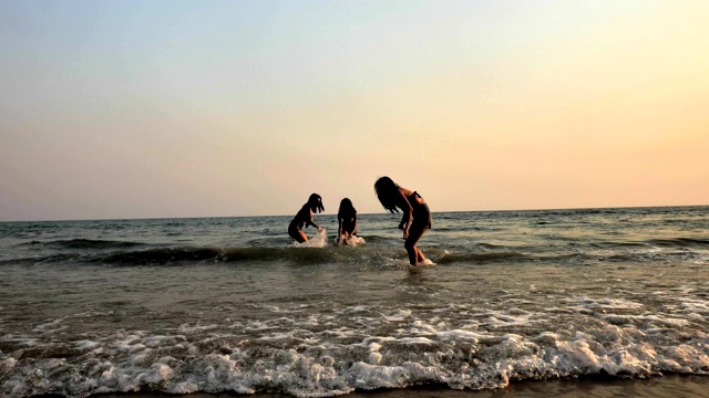 日落时分，一群年轻女子在海滩上嬉戏视频素材