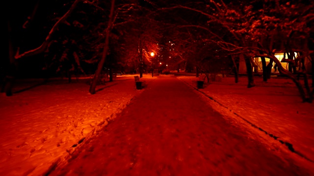 冬天街灯照亮的空巷。走在积雪覆盖的小径上视频素材