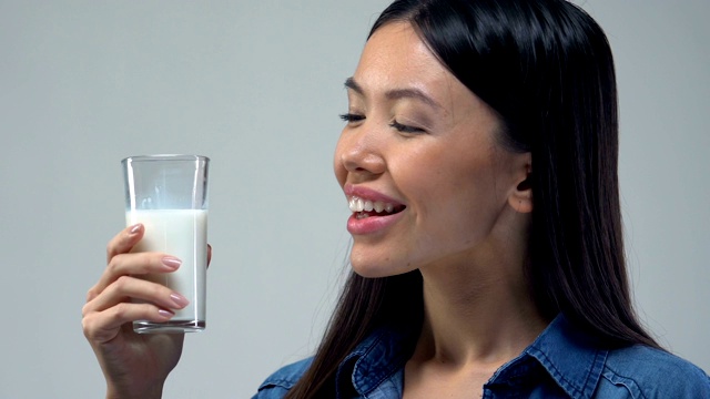 美丽的亚洲女人喝一杯牛奶，健康饮食，必需营养视频素材