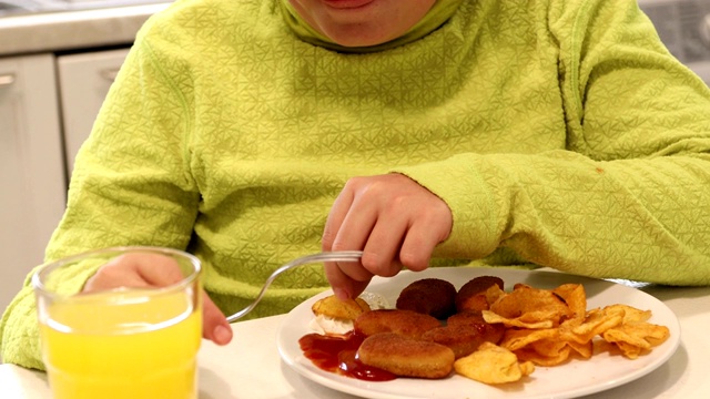 孩子们在吃鸡块和薯片视频素材