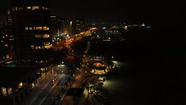 特拉维夫市的夜景鸟瞰图与现代天际线和豪华酒店在以色列特拉维夫市港口附近的海滩。视频素材