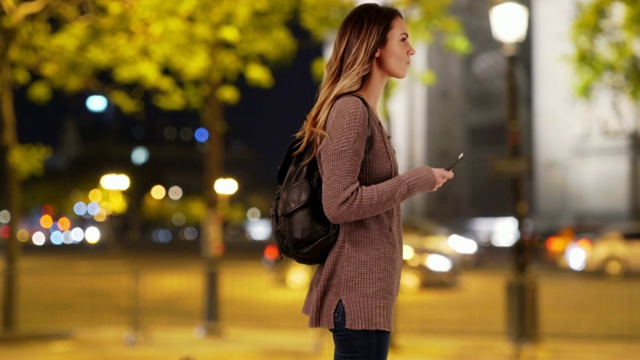 迷人的白人女人在城市里用她的手机微笑视频素材