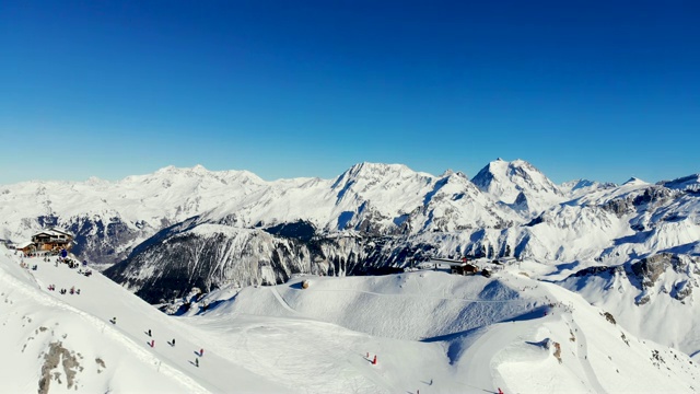 滑雪者在美丽的阿尔卑斯山滑雪坡上，人们在冬季度假。冬天的山景观视频素材