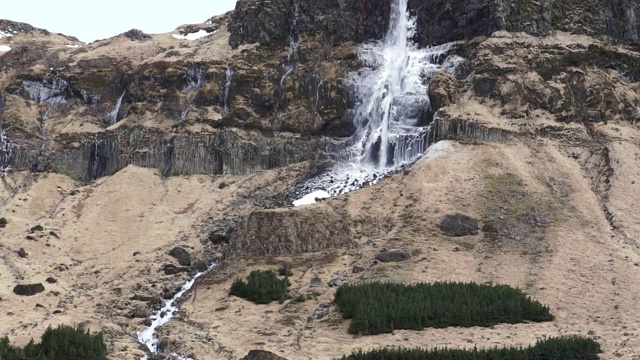 雄伟的冰岛冻结瀑布在高悬崖火山景观视频素材