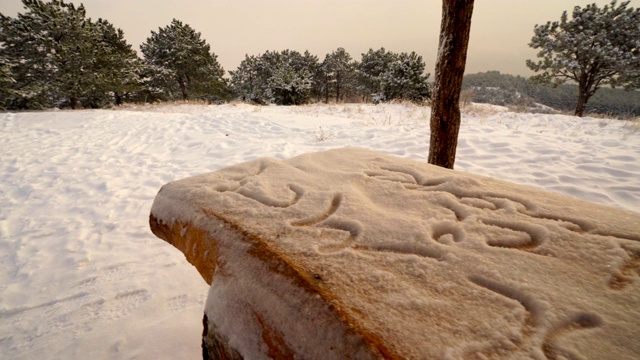 铺着雪的大木制野餐桌。在冬天的雪山野餐区视频素材