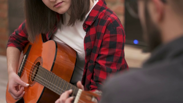 小女孩在弹原声吉他，男朋友在看着她视频素材