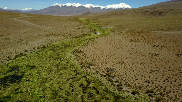 Altiplano山谷内的安第斯山脉在通往乌尤尼盐滩的道路上，一个惊人的风景从无人机上俯瞰4x4汽车和人们在绿色山谷玻利维亚旅行视频素材