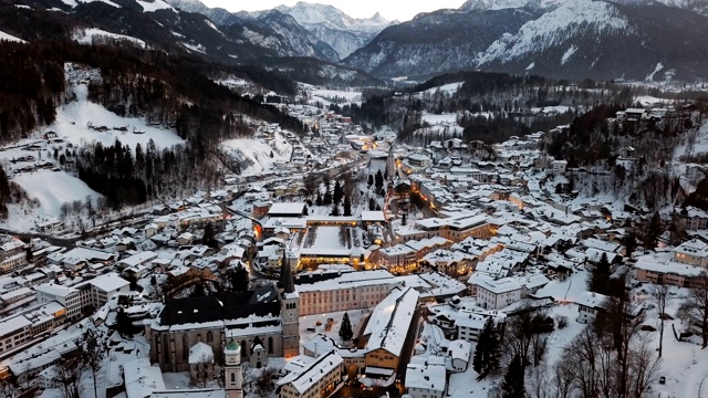 德国巴伐利亚的贝希特斯加登老城区被冬季积雪覆盖的夜景鸟瞰图。视频素材