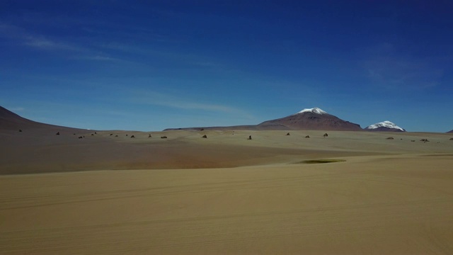 “Siloli”沙漠和彩色山脉在通往乌尤尼盐滩的路上，这是一个令人惊叹的干旱景观，从无人机上俯瞰4x4汽车和旅行的人，玻利维亚视频素材