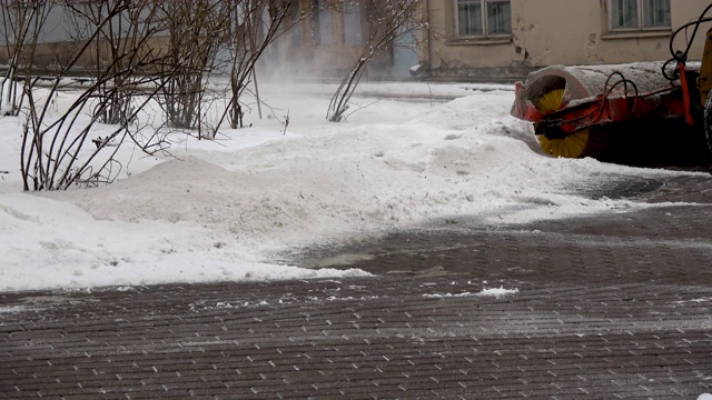 拖拉机清理城市广场人行道上的积雪视频素材