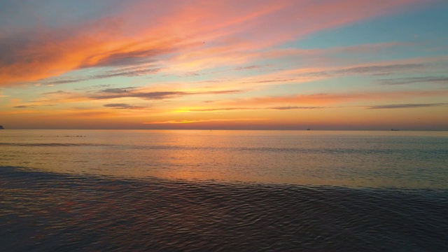 日出和热带海滩。海浪冲刷着沙子。视频素材