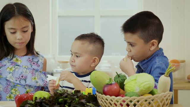 孩子们喜欢在家里的厨房里吃苹果，快乐的家庭观念视频素材