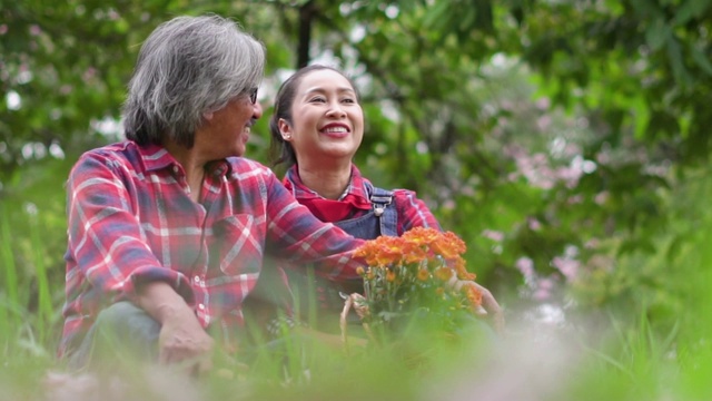 慢镜头:老农夫妇在花园里愉快地坐着聊天。视频素材