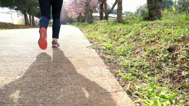 慢动作:女跑步者在跑道上跑步，腿靠近视频素材