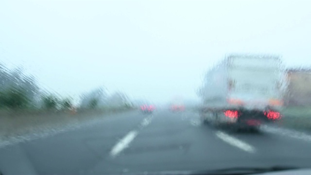 一辆汽车在阴雨天在高速公路上行驶的模糊视频。视频素材