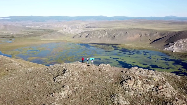 空中-一个人站在山顶上的剪影。女人爬完山后胜利地举起双臂视频素材