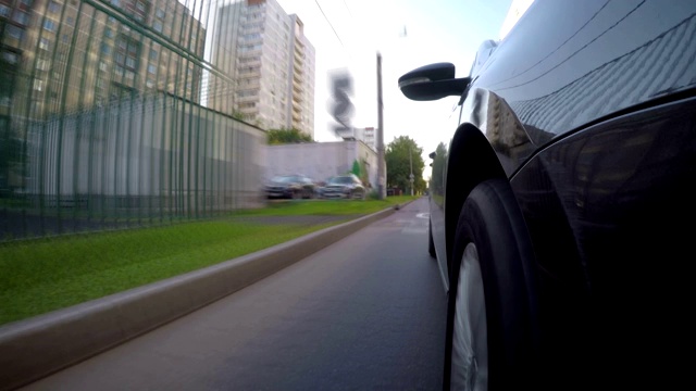 时光流逝，汽车在阳光明媚的夏日沿着城市街道行驶。车身的正面视图。视频素材