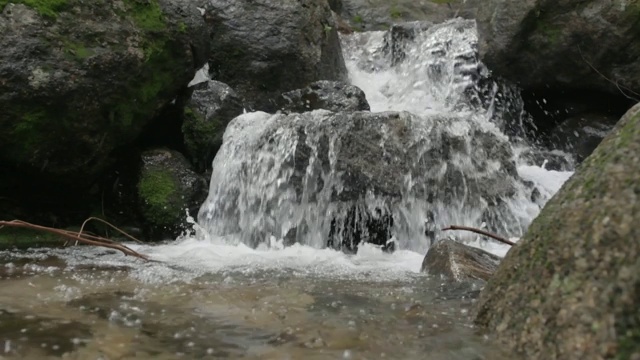 近距离观察干净的山水溅在岩石上视频素材