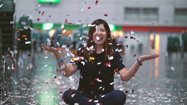 4k视频中，迷人的亚洲女性在房间里庆祝并投掷五彩纸屑，庆祝新年快乐和派对理念视频素材