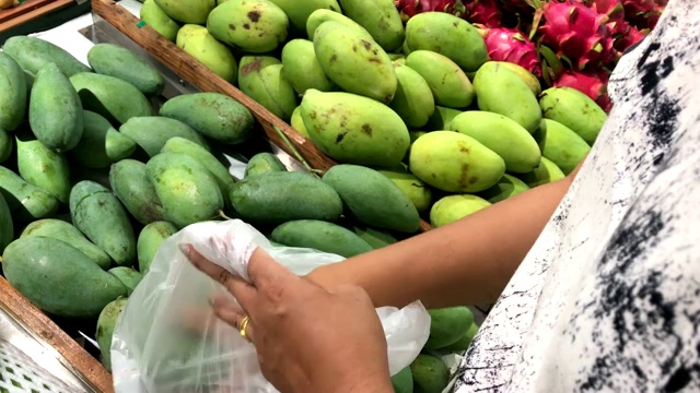 女人的手在超市买新鲜的有机食品，芒果视频素材