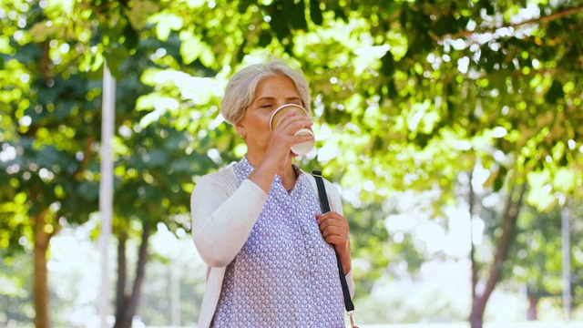 快乐的老女人在夏日公园喝咖啡视频素材