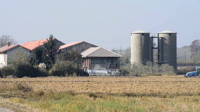 农场和拖拉机在平原的田地里工作视频素材