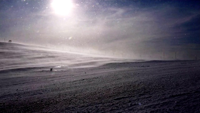 雪坡上的暴风雪和滑雪者在夕阳下的剪影视频下载