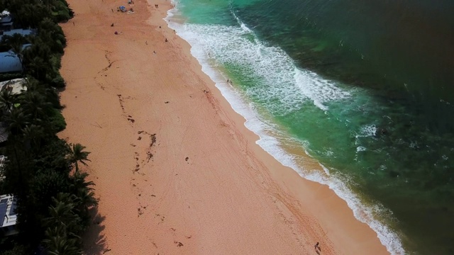 航拍:在有沙滩、蓝色海洋和蓝天的海岸线上平移视频素材