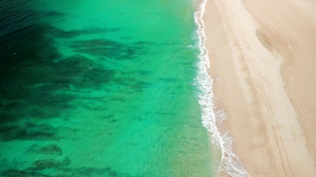 天线:绿色的海洋，柔和的海浪和沙滩，和远方的人们在一起视频素材