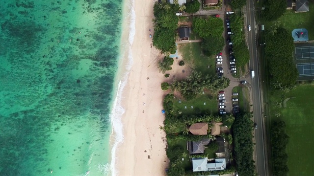 鸟瞰图:海岸线的一部分，有清澈的海洋，海滩，建筑物和道路视频素材