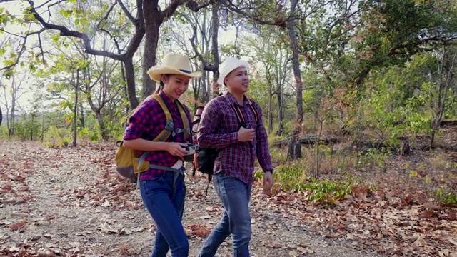 年轻的亚洲夫妇背包徒步旅行，享受走在泰国山区森林小径视频素材