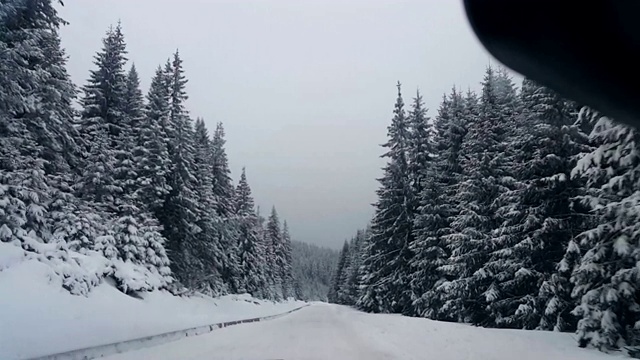 POV驾驶在积雪覆盖的道路上，在白天，大雪暴风雪视频素材