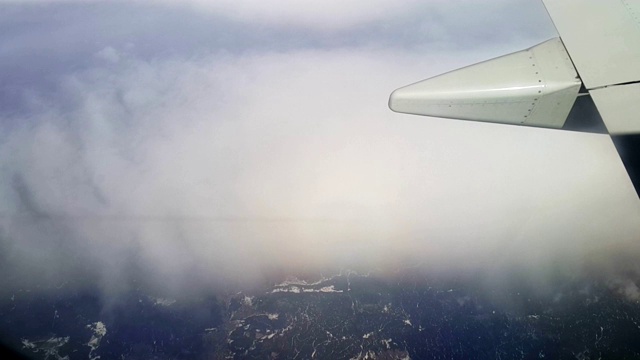 乘客的POV从飞机的窗口上方飞过低空云层，飞越威尼斯泻湖的岛屿。飞机，飞行，机翼视频素材