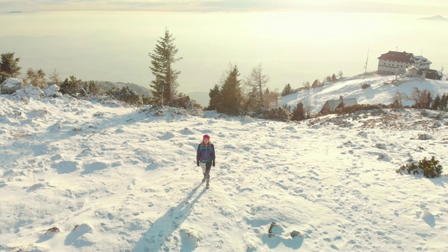 一名女子在雪山上徒步旅行视频素材