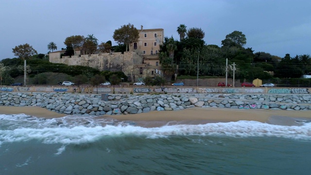 航拍全景，在公路上运行的汽车和海边高速公路与十字路口靠近马努海滩，蒙哥马利，西班牙巴塞罗那。傍晚天空有云。视频素材