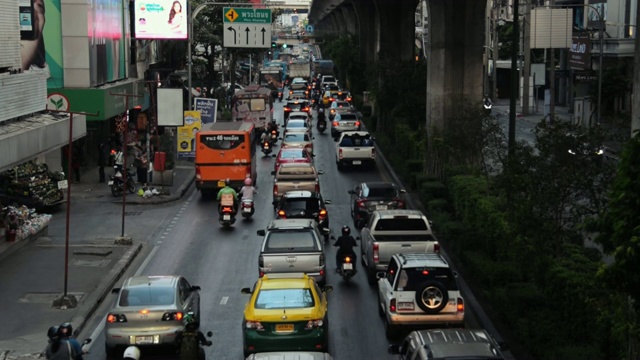 曼谷交通远离镜头，从上面看，日落，汽车和公共汽车沿着道路与自行车交织。视频素材