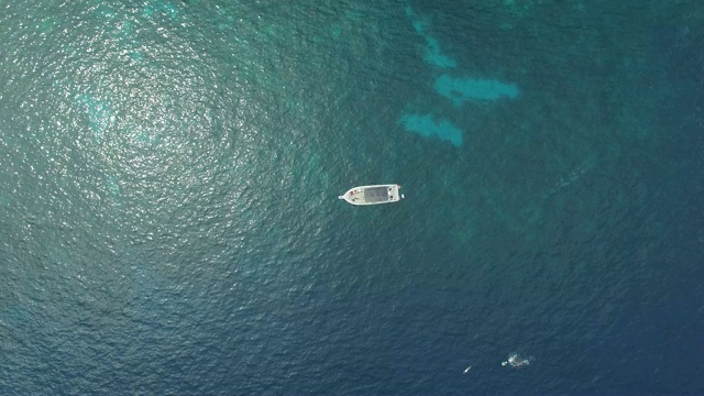 天线:漂浮在蓝色水中的小船，阳光反射视频素材