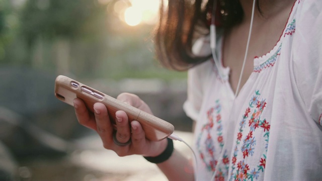 年轻的亚洲女人用耳机听音乐。视频素材