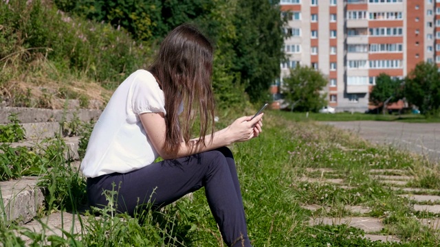 一个面目全非的女人在电话上输入一条信息。视频素材