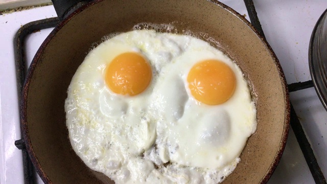 用平底锅煮鸡蛋。前视图。视频素材