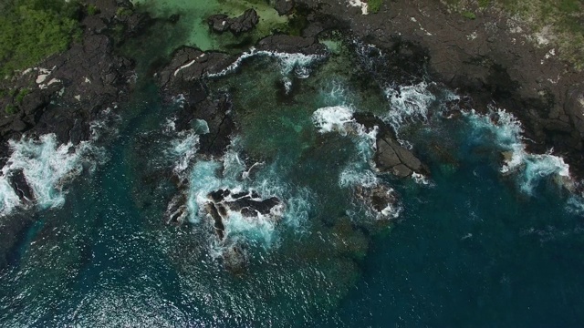 空中:蓝色的海洋，白色的海浪冲击着岩石海岸和宽阔的山谷视频素材