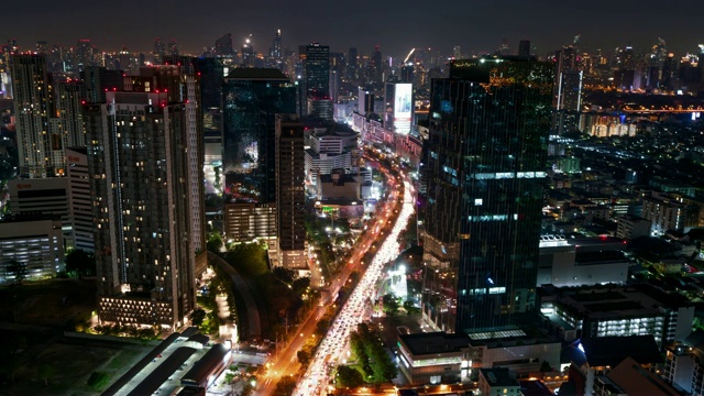 时间流逝:曼谷摩天大楼之间繁忙的道路在夜晚视频素材