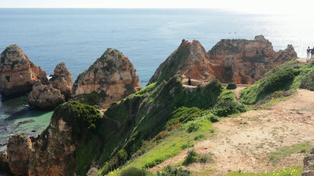 蓬塔·达·皮达德，葡萄牙南部著名的地方，拉各斯市，岩石海岸，大西洋的波浪，尖锐的岩石，蔚蓝的水，黄色的花，拱门，没有人，野生的海滩视频素材