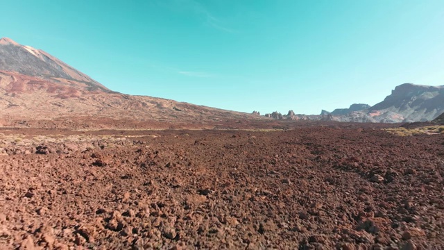 空中无人机拍摄。红色的沙漠火山景观。蓝色的天空映衬着石头和一座火山山。殖民和飞往火星和其他星球的概念视频素材