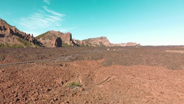 空中射击。加那利群岛，泰德火山。国家公园。在高山公路上乘坐汽车行驶在沙漠山谷中，背景是红色和蓝色的天空。殖民和迁移到火星和其他星球的概念。反向运动视频素材