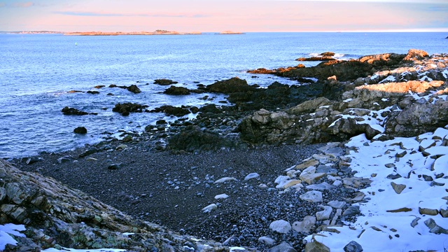 在马萨诸塞州的冬天，岩石和雪俯瞰着海洋和海岸视频下载